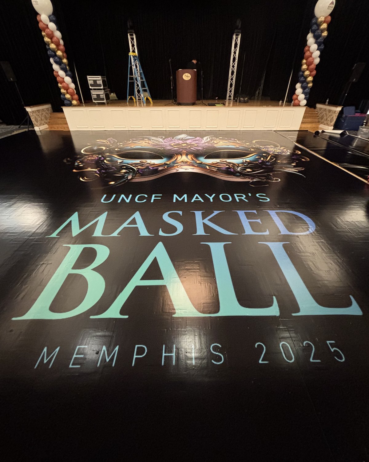 A UNCF Mayor's Masked Ball Memphis 2025 floor wrap in front of the stage