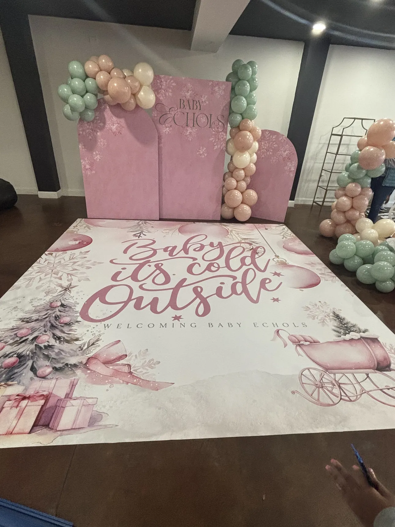A baby shower dance floor wrap in front of a pink arch backdrop