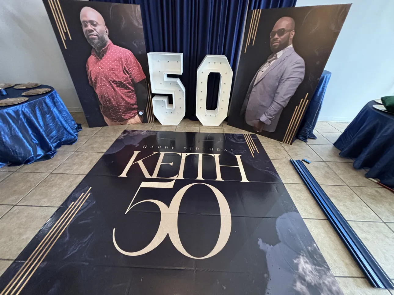 A Keith 50 dance floor wrap with two large photo cutouts behind it