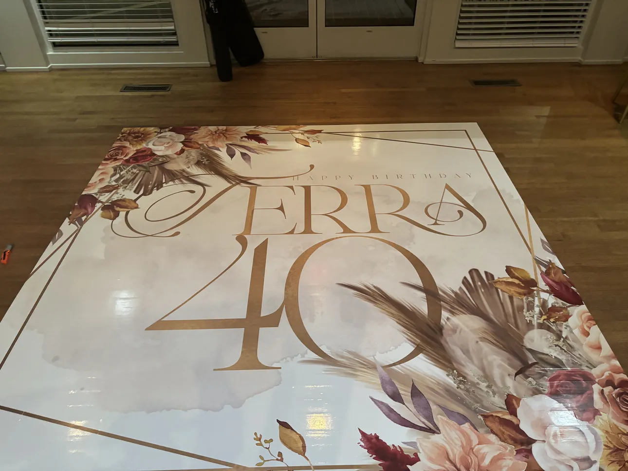 A white and gold floral Happy Birthday 40 dance floor wrap