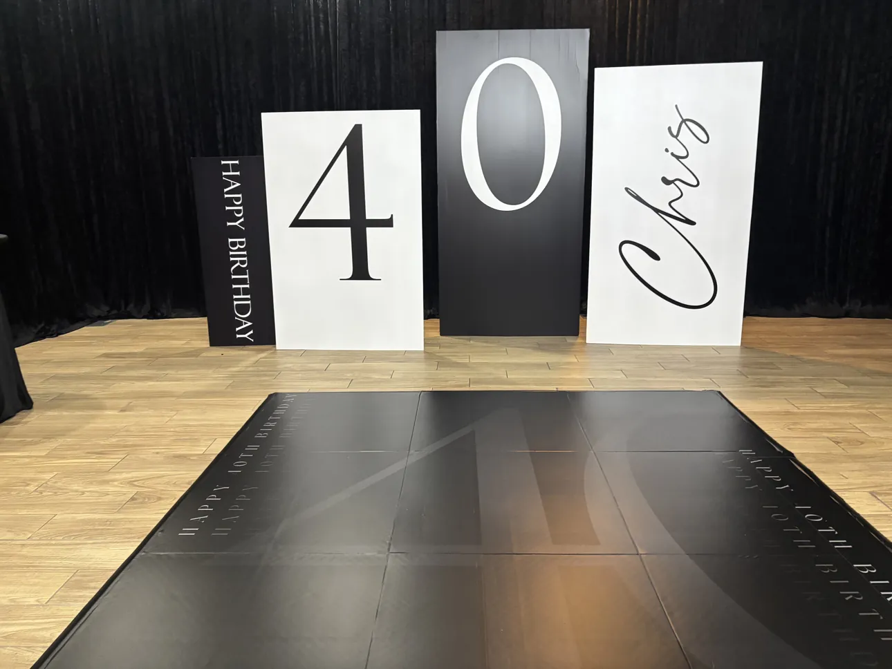 Custom 4, 0 and name panels standing behind a 40th birthday dance floor