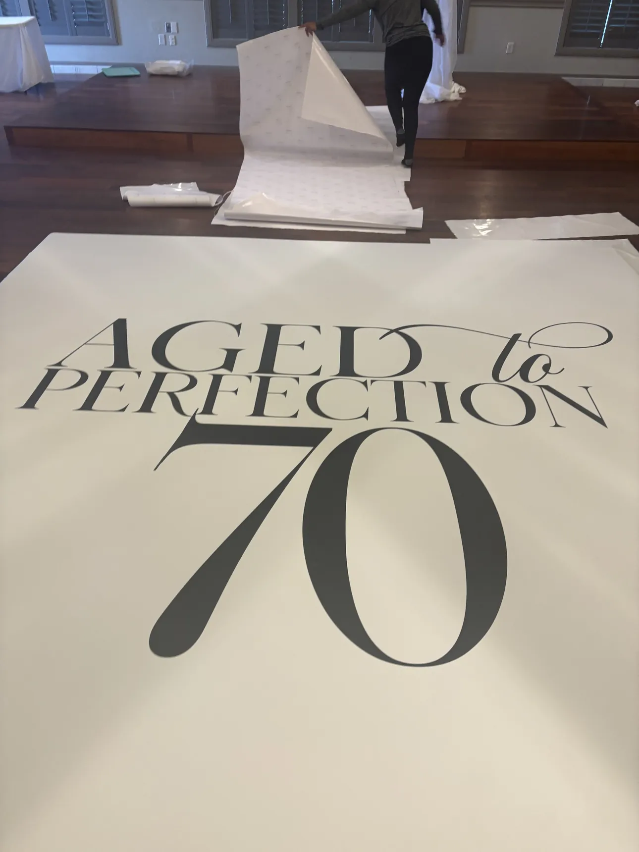 An Aged to Perfection 70 dance floor wrap being installed