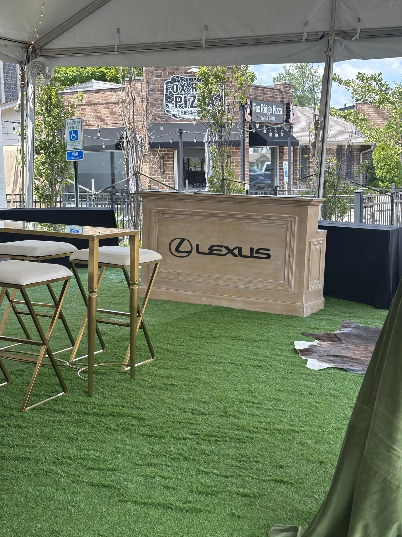 A Lexus logo bar wrap at an outdoor brand lounge