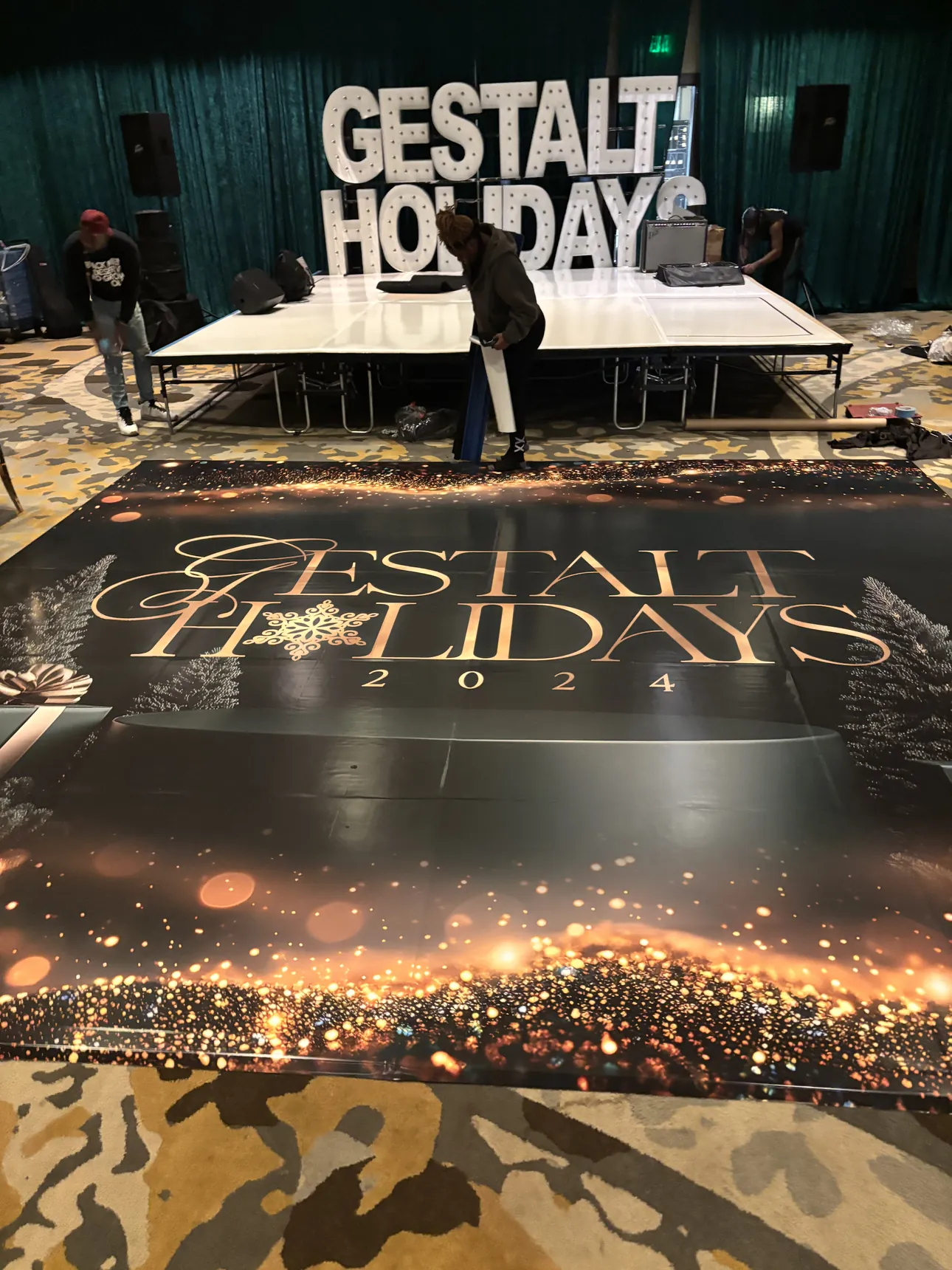 A Gestalt Holidays 2024 floor wrap with gold sparkle