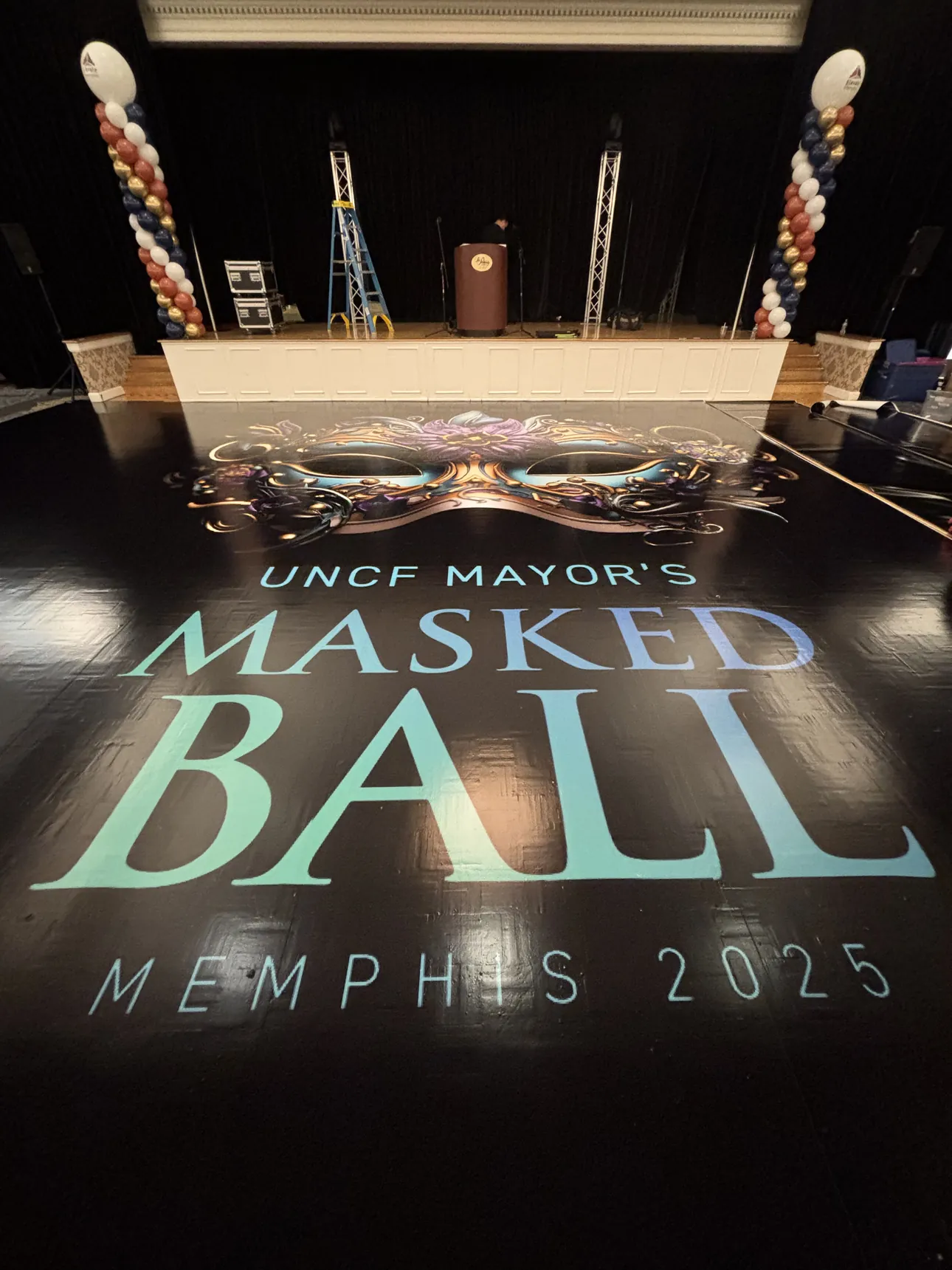 A UNCF Mayor's Masked Ball Memphis 2025 floor wrap in front of the stage