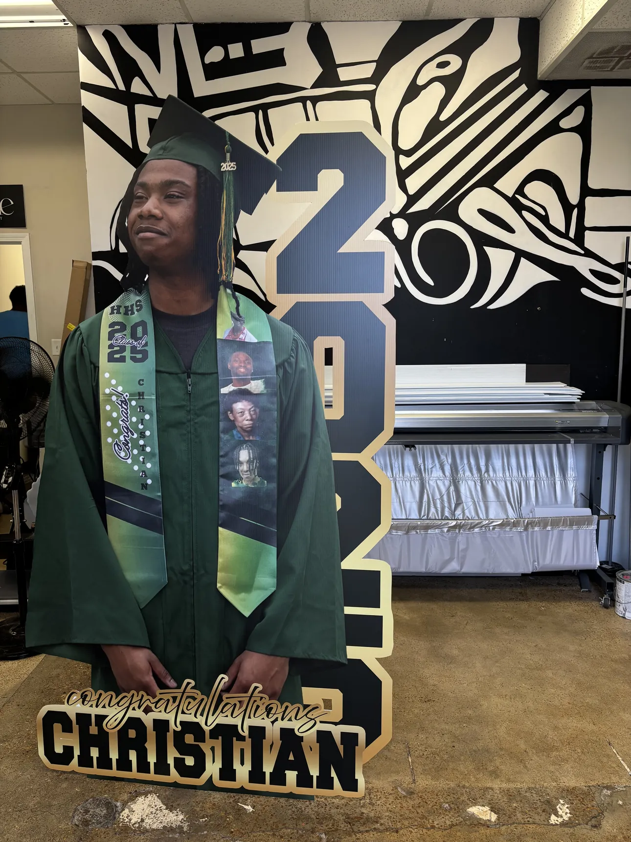 A custom graduation cutout standing in the studio before pickup
